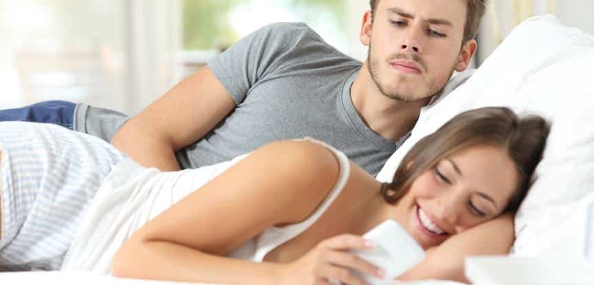 homem desconfiado de mulher mexendo no celular