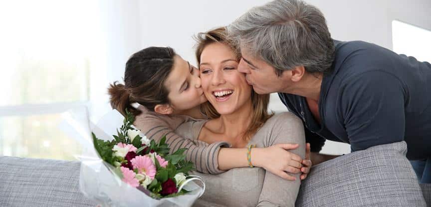 filha e marido beijando mãe