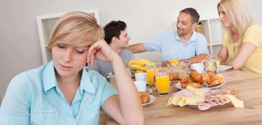 família feliz em volta da mesa do café da manhã excluindo filha