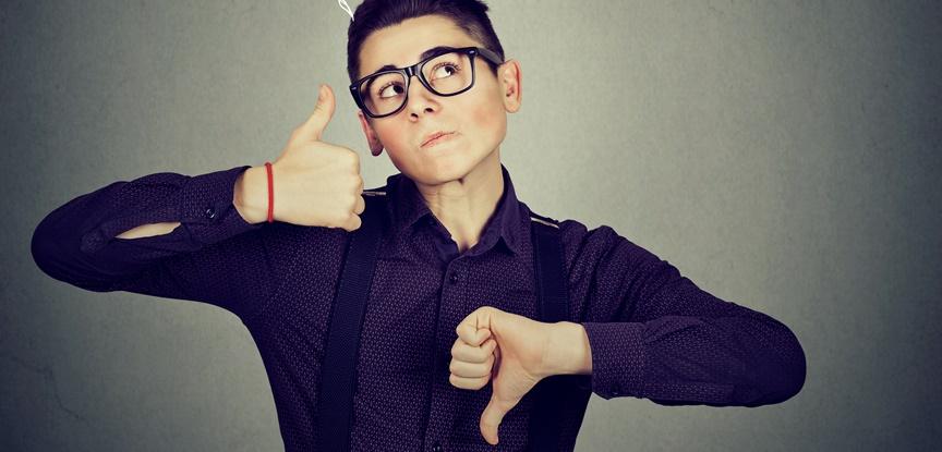 menino com as mãos fazendo sinais de positivo e negativo