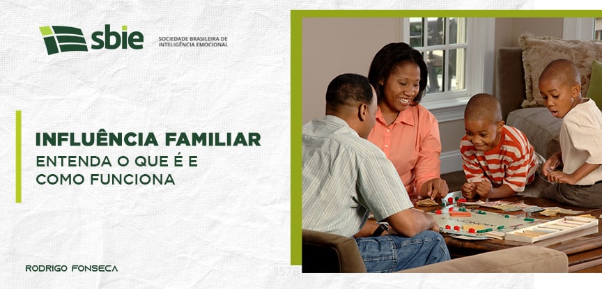 Na imagem há uma família feliz reunida em volta de uma mesa, fazendo referência ao tema influência familiar